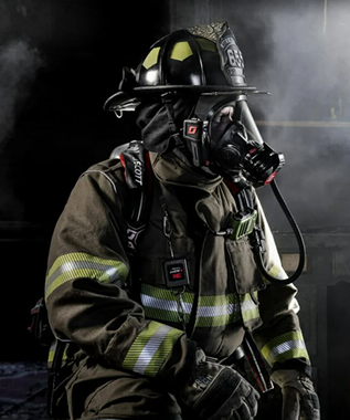 Firefighter in full gear with a dark background