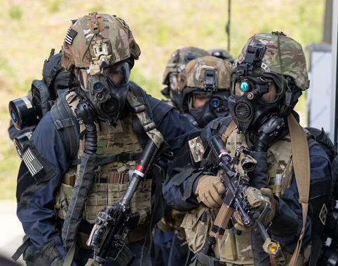 Three soldiers in tactical gear with gas masks and rifles outdoors.